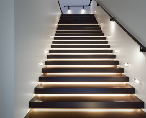 Motion sensor stair lights Toronto: Modern dark wood staircase with soft, diffused lighting.